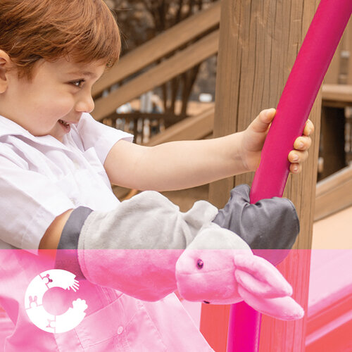 boy wearing cast cover critter while playing on playset