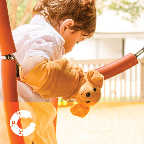 boy playing while wearing cast cover critter